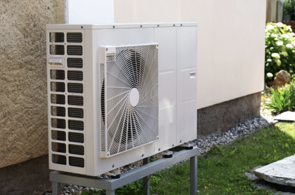 Air Source Heat Pump Installed Outside of a House in a Yard.