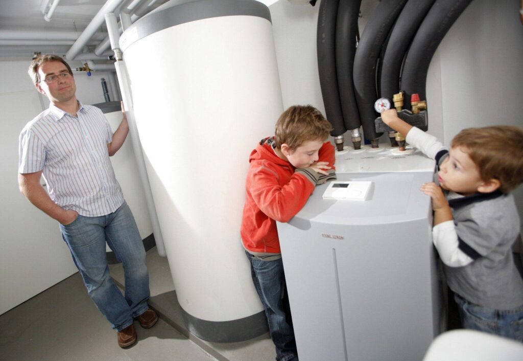 Family checking on their heat pump in a basement