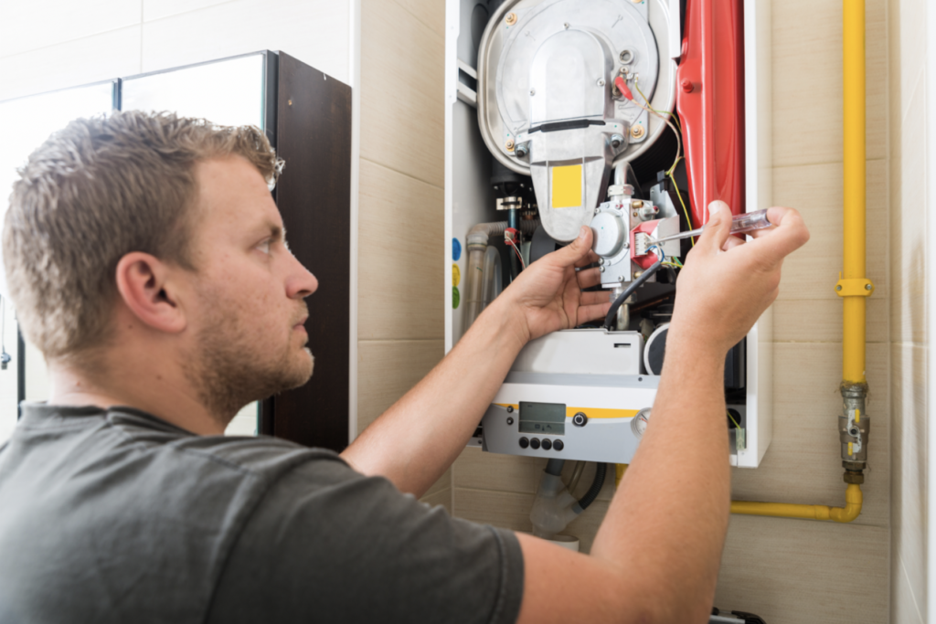 HVAC Technician Installing Components Inside Gas Furnace